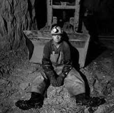 An exhausted miner sitting on the ground
