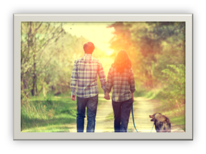 Couple walking a dog down a trail