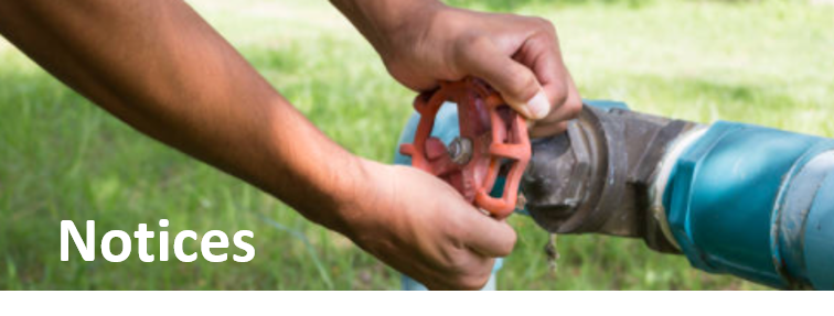 Mans hands turning off a large valve with the words Notices