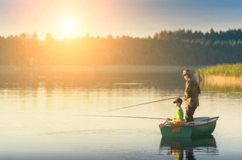 Man and boy in fishing boat fishing